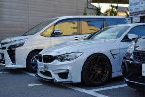 Muso di due auto di colore bianco parcheggiate e viste di lato